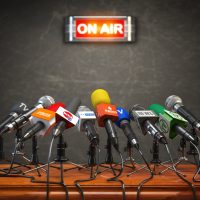 Press conference or interview on air.  Microphones of different mass media, radio, tv and press prepared for conference meeting.
